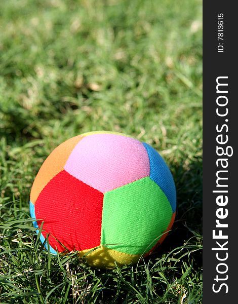 A coloured funny sporty ball on the grass. A coloured funny sporty ball on the grass