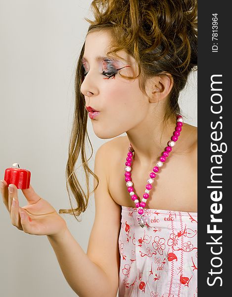 Fashion girl blowing out red heart shaped valentine's day candle. Fashion girl blowing out red heart shaped valentine's day candle