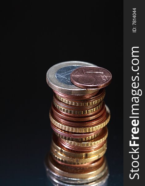 Close-up of european coins column on dark background. Close-up of european coins column on dark background