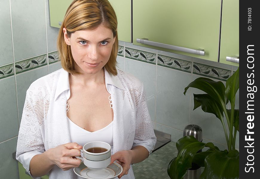 A young woman in the kitchen drinking coffee. A young woman in the kitchen drinking coffee