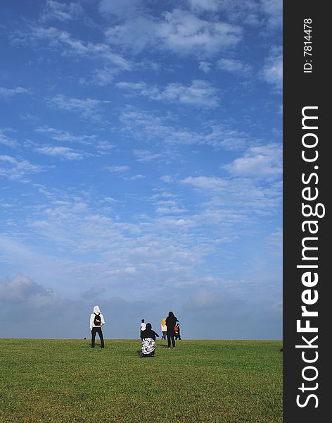 A group of Malays wearing their traditional headgear in a field relaxing and enjoying the beautiful blue skies. A group of Malays wearing their traditional headgear in a field relaxing and enjoying the beautiful blue skies.