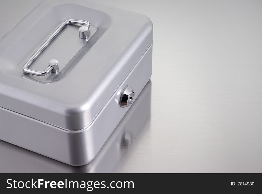 Metal cash box on metallic background