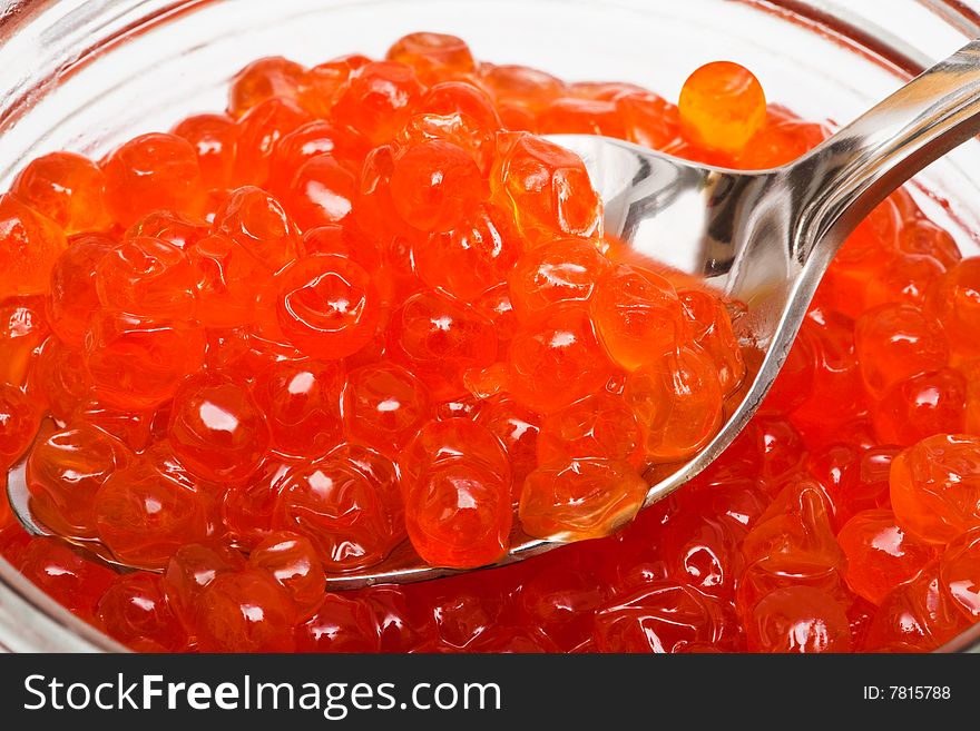 The spoon and red caviar in glass can