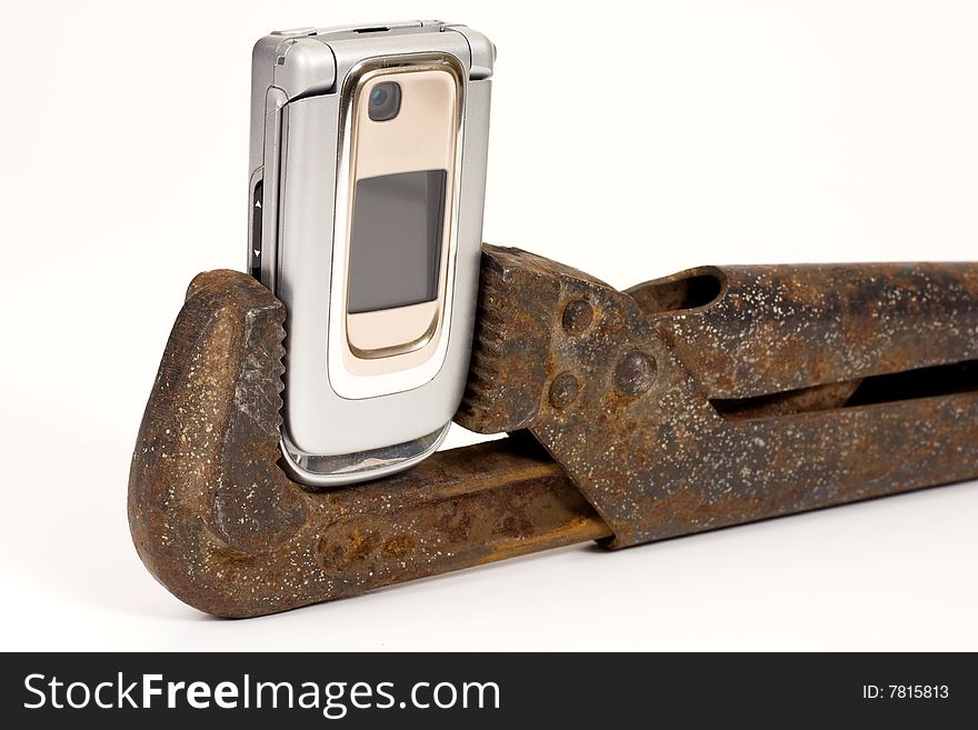 Old rusty spanner and modern telephone. Old rusty spanner and modern telephone.