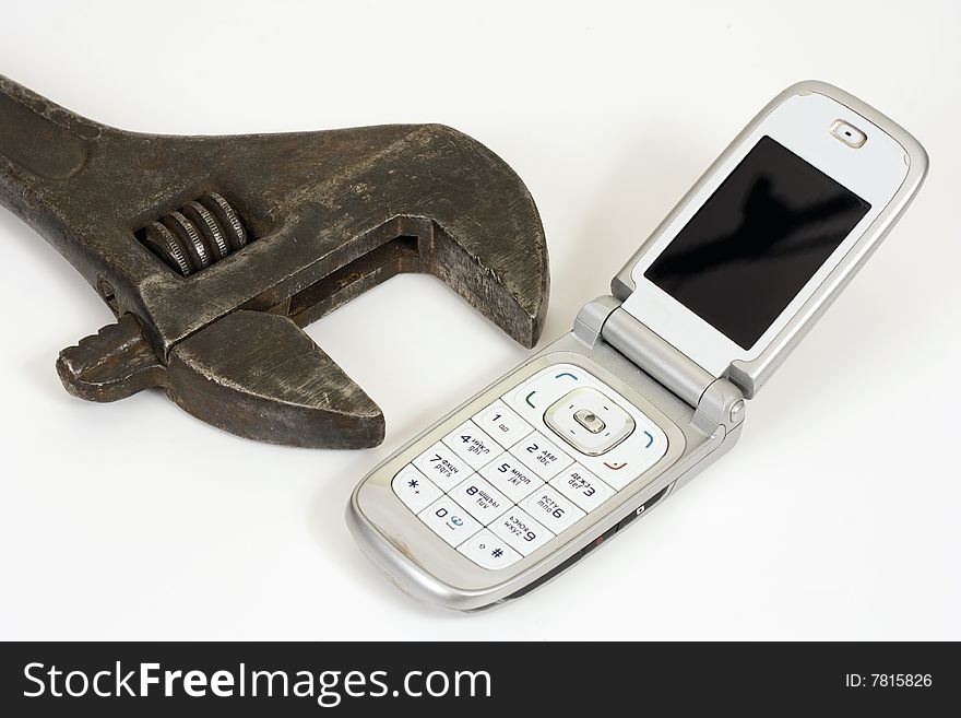 Old spanner and modern telephone. Old spanner and modern telephone.