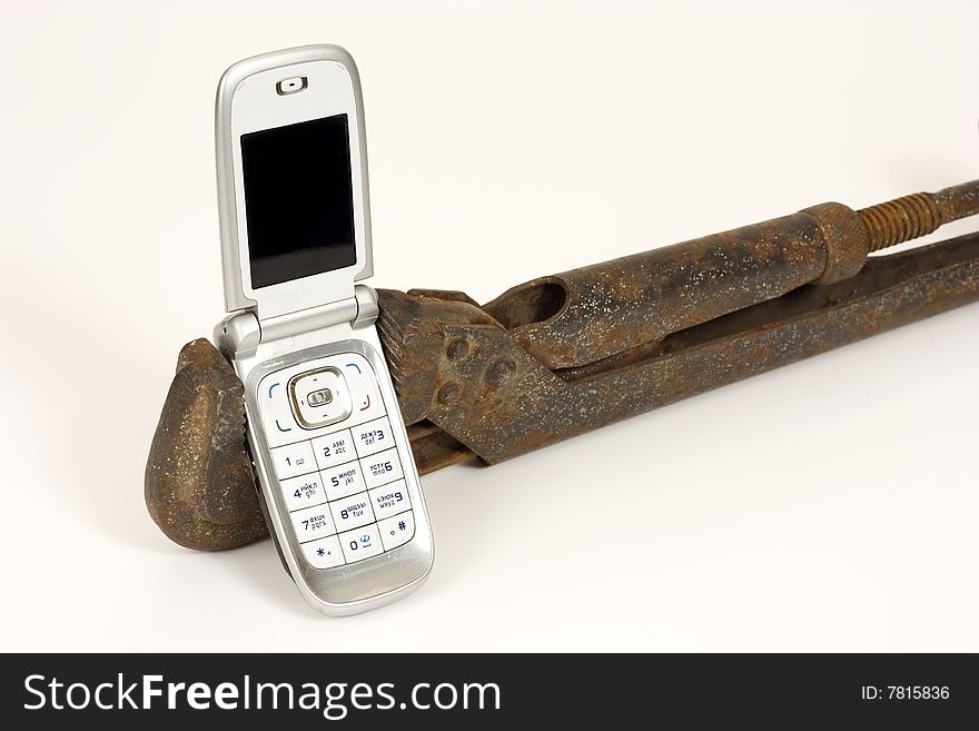 Old rusty spanner and modern telephone. Old rusty spanner and modern telephone.