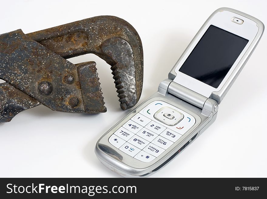 Old spanner and modern telephone. Old spanner and modern telephone.