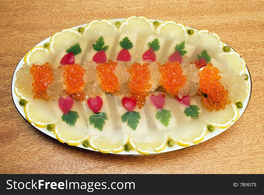 The large dish with appetizer on a background of a light tree. The large dish with appetizer on a background of a light tree