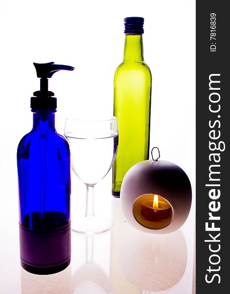 Brightly colored bottles and a lit candle. Brightly colored bottles and a lit candle