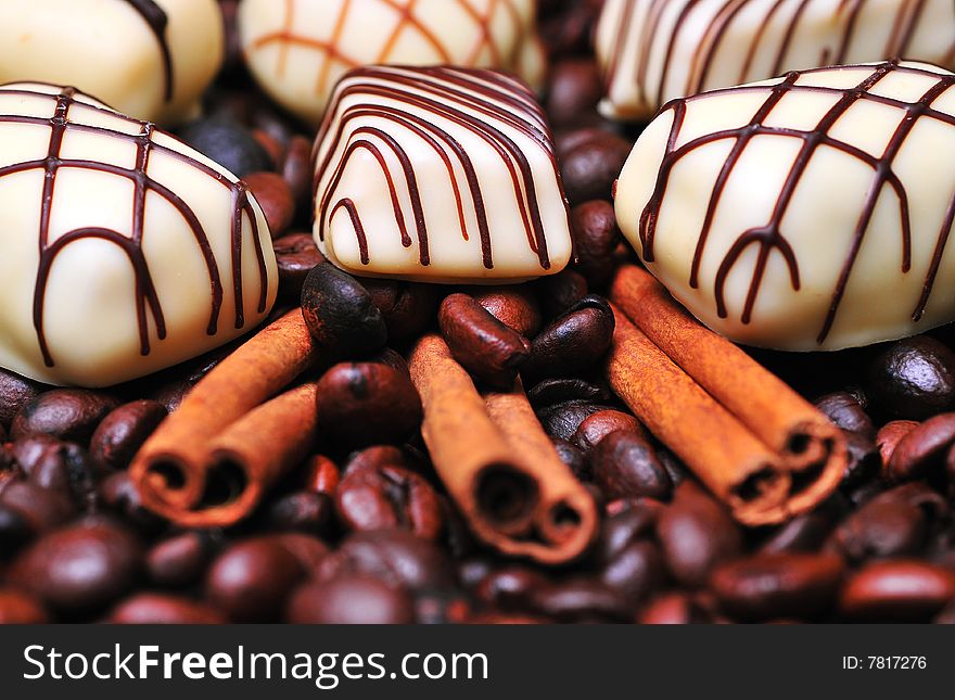 Chocolates with cinnamon on a stack of coffee beans background