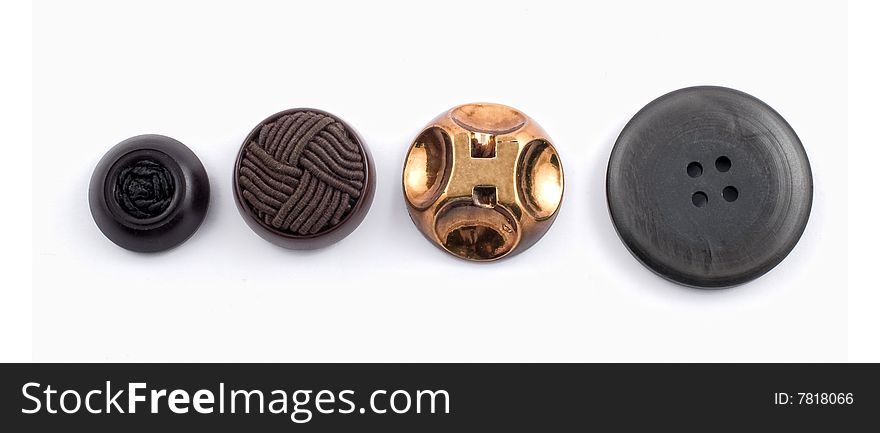 Four assorted buttons in a row on white background