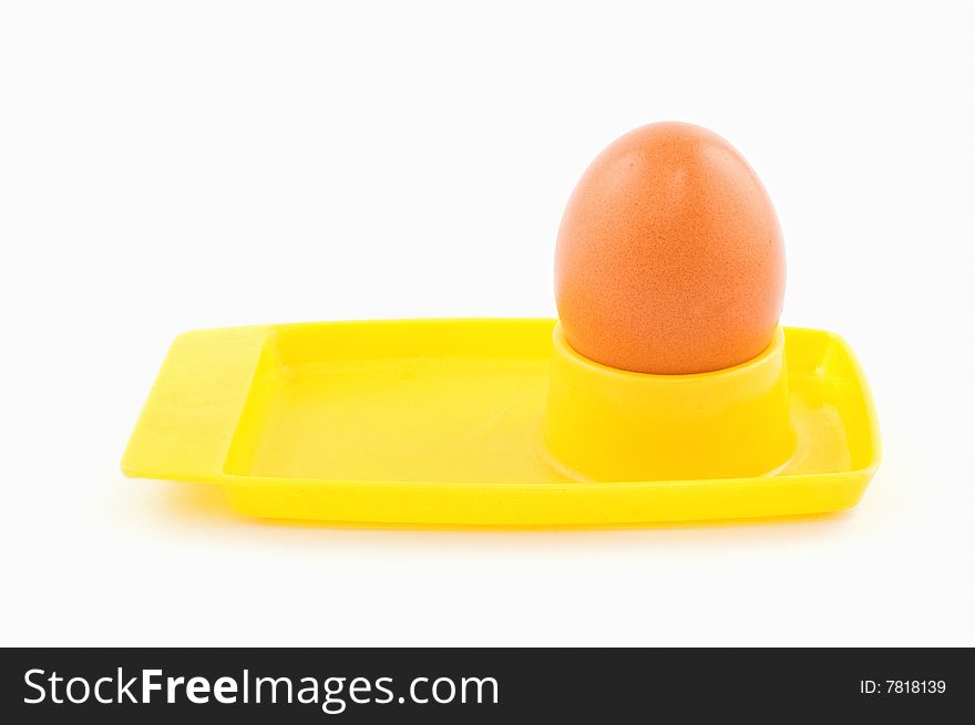 Egg in yellow egg holder isolated on white
