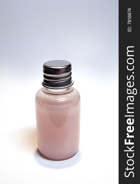 Bottle with pink liquid on white background