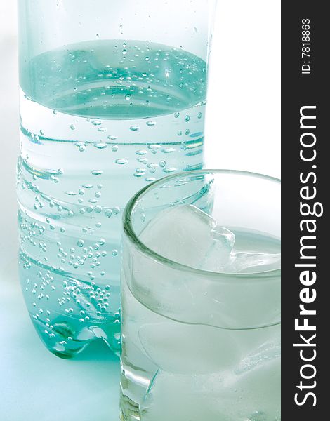 Plastic bottle and glass with pure water.