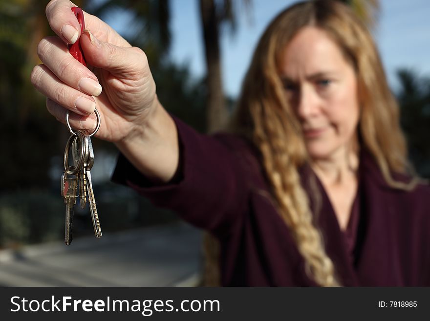 Woman holding out a set of keys. Woman holding out a set of keys