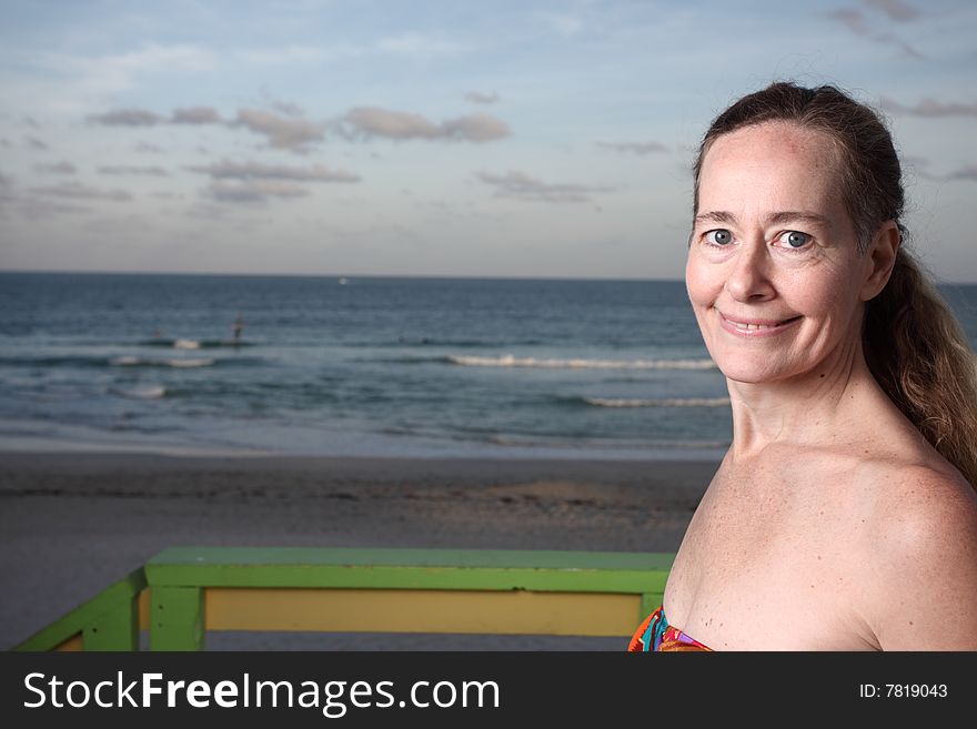 Woman smiling with the ocean in the background. Woman smiling with the ocean in the background