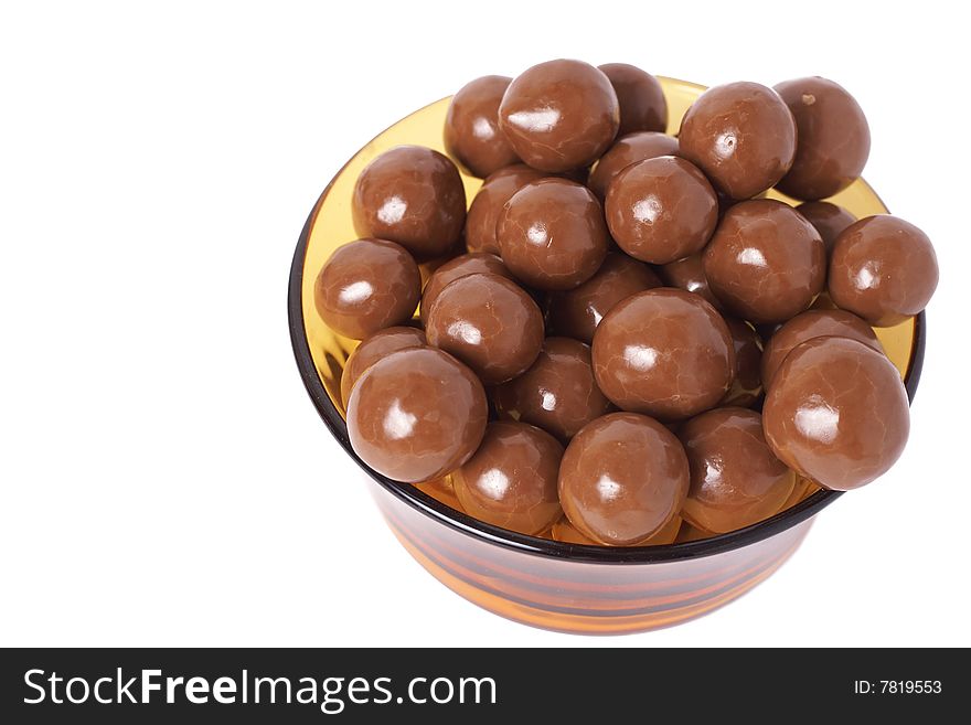 Small chocolate balls in glass bowl isolated on white background with copy space. Shallow depth of field