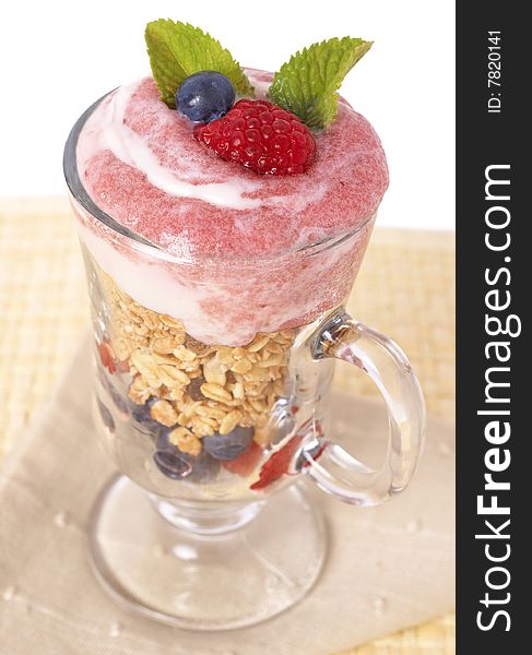 Healthy breakfast with muesli, raspberries, blueberries and yoghurt, decorated with mint leaves in a glass. Healthy breakfast with muesli, raspberries, blueberries and yoghurt, decorated with mint leaves in a glass