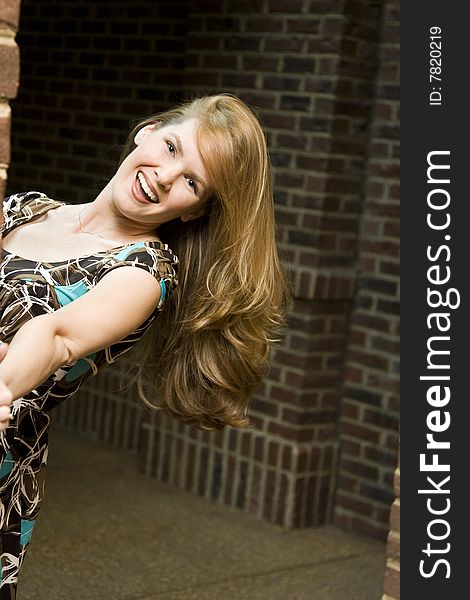 Young Woman with Hair Down Against Brick Background