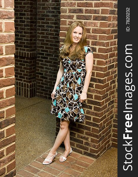 Young Woman with Happy Expression Standing Against Brick Background. Young Woman with Happy Expression Standing Against Brick Background