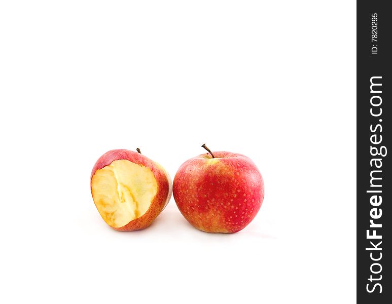 Two delightful ripe apples on the white background, one is bitten. Two delightful ripe apples on the white background, one is bitten