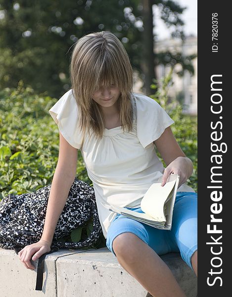 Teenager looks through notes in the park