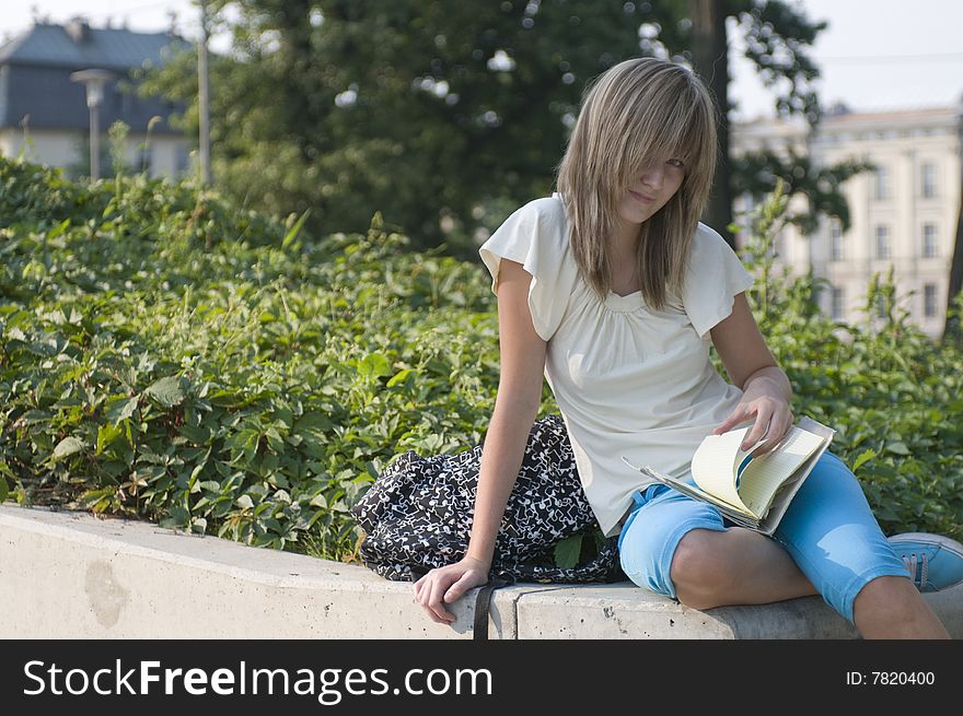 Teenager looks through notes in the park