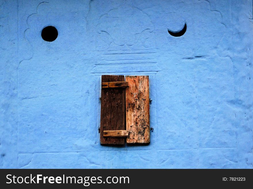 Little close window and blue wall with sun and moon symbols, Rajasthan, India. Camera: Nikon D70 with Sigma 70-300 mm