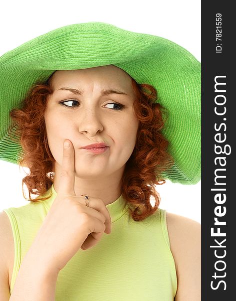 Thoughtful young woman with ginger hair wearing a green summer hat