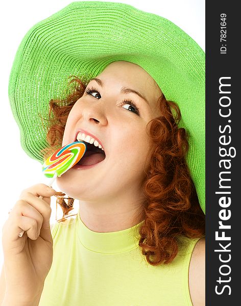 Happy young woman with ginger hair eating a colorful candy. Happy young woman with ginger hair eating a colorful candy