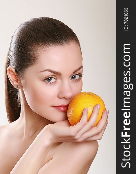Attractive Woman Holding Orange In Studio