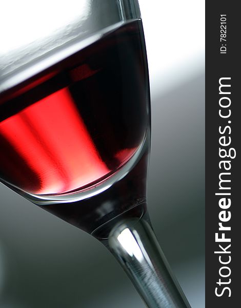 Glass with red wine. A fragment. Accent on color of wine.