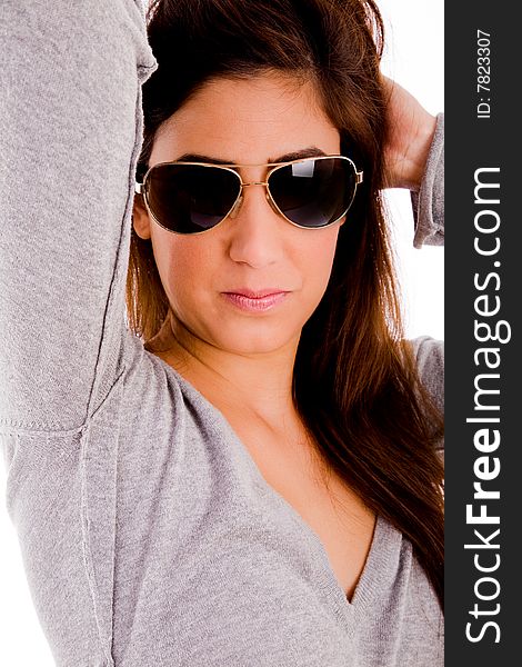 Portrait of smiling model with sunglasses holding her hair against white background