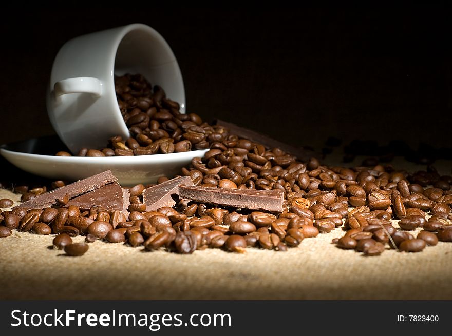 Still life with cup of coffee and coffee-beans on the sackcloth