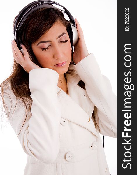 Portrait of young female enjoying music against white background