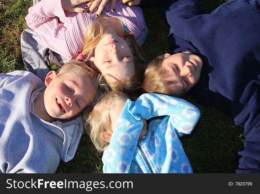 Four kids laying on the ground. Four kids laying on the ground