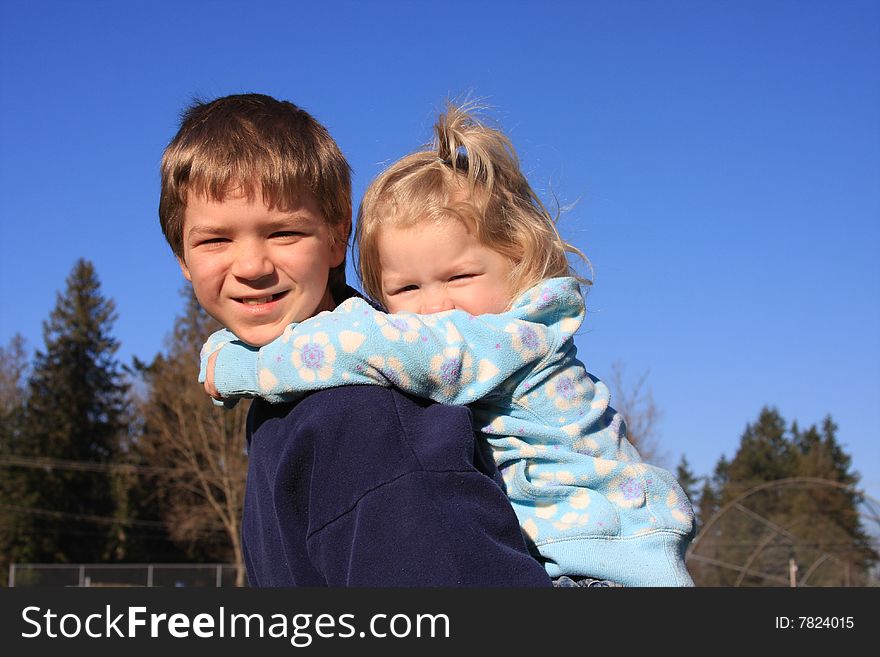 Older brother giving younger sister a piggy back ride. Older brother giving younger sister a piggy back ride