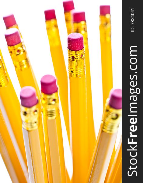 Yellow pencils with a rubber on the end in a glass