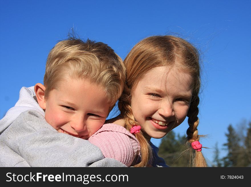 Bigger sister giving little brother a piggy back ride. Bigger sister giving little brother a piggy back ride