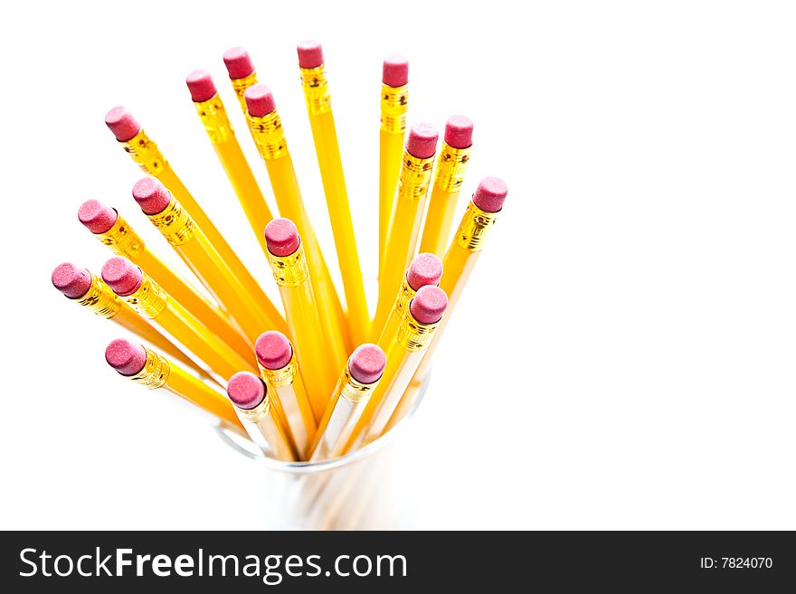 Yellow pencils with a rubber on the end in a glass