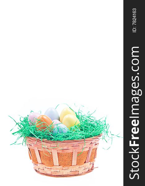 Easter basket full with coloured eggs and green grass