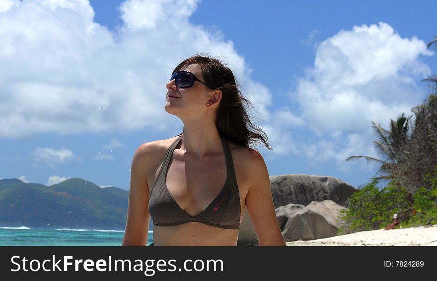 A young girl enjoys sunrays at the beach of Anse Sorce dÂ´Argent, La Digue, Seychelles. A young girl enjoys sunrays at the beach of Anse Sorce dÂ´Argent, La Digue, Seychelles.