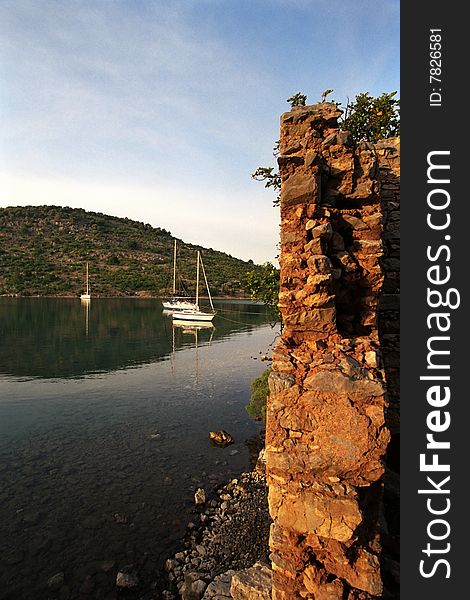 Anchoring yacht at beautiful coast in mediteranian sea near bizantian ruins. Anchoring yacht at beautiful coast in mediteranian sea near bizantian ruins