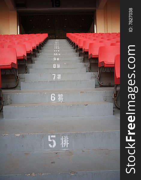 Steps leading up through rows of empty stadium seats. Steps leading up through rows of empty stadium seats.