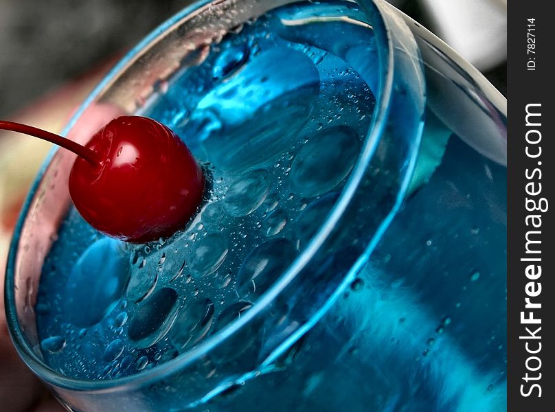 A red cherry splashing into blue water