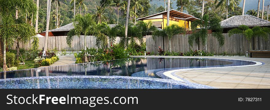 Swimming pool and jacuzzi in the health resort surrounded by exotic vegetation. Leisure and relaxation concept. 2H panorama. Swimming pool and jacuzzi in the health resort surrounded by exotic vegetation. Leisure and relaxation concept. 2H panorama.