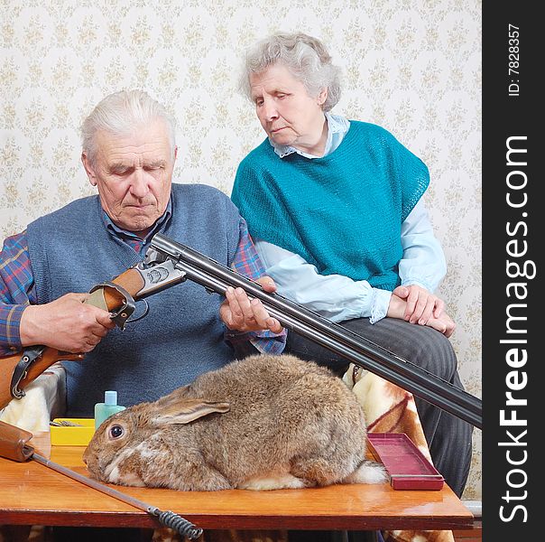 Grandfather load rifle, and grandmother look on it. Grandfather load rifle, and grandmother look on it