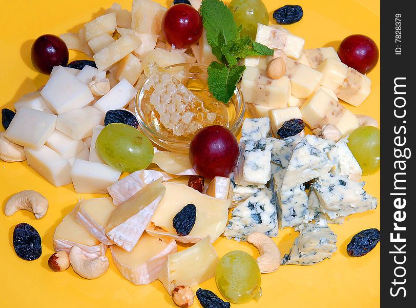 Versions of cheese with honey and fruit on a yellow plate