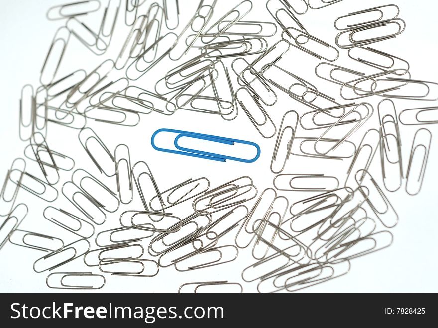 Blue paper clip between bunch of grey ones. Blue paper clip between bunch of grey ones