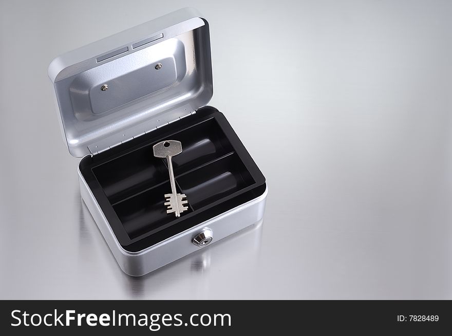 Metal key inside metallic box. Metal key inside metallic box